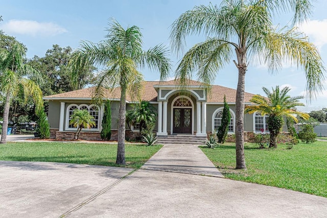 2638 E Knights Griffin Rd, Plant City, FL 33565 - view of front of property with stucco siding, french doors, and a front lawn
