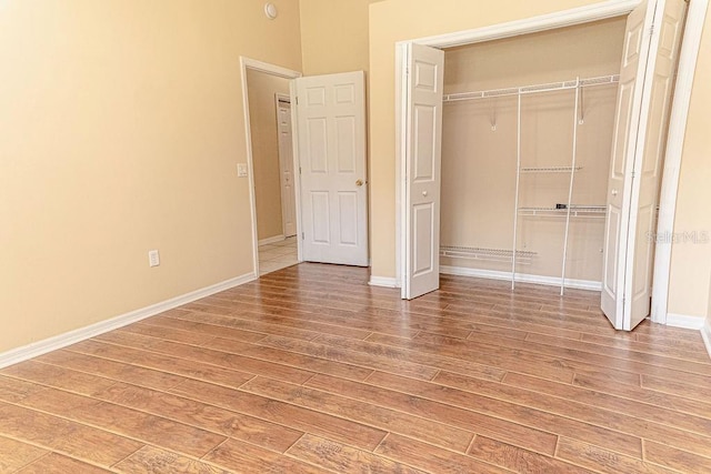 2638 E Knights Griffin Rd, Plant City, FL 33565 - unfurnished bedroom featuring light wood-type flooring, a closet, and baseboards