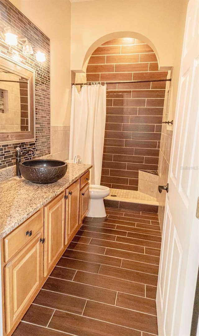 2638 E Knights Griffin Rd, Plant City, FL 33565 - bathroom with a tile shower, vanity, toilet, and wood finished floors
