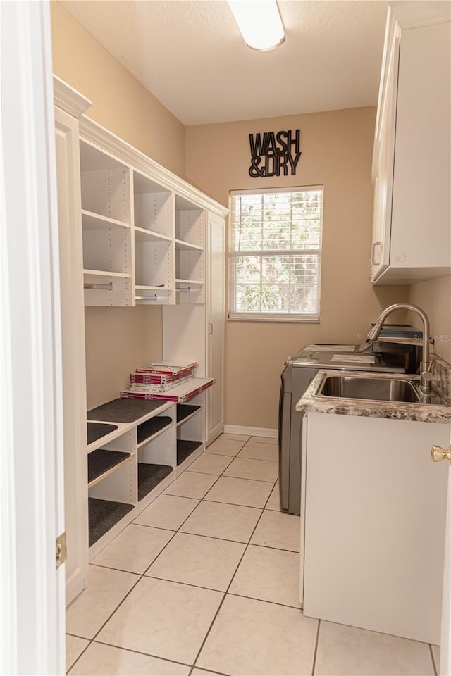 2638 E Knights Griffin Rd, Plant City, FL 33565 - washroom featuring cabinet space, separate washer and dryer, light tile patterned floors, and baseboards