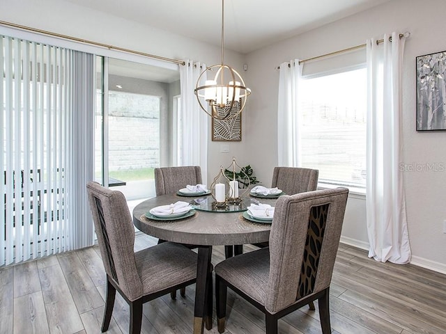 dining area with a wealth of natural light, light hardwood / wood-style flooring, and a chandelier