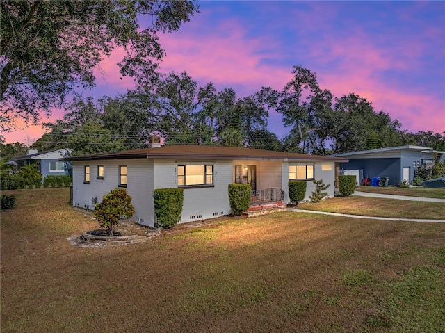 ranch-style home featuring a lawn