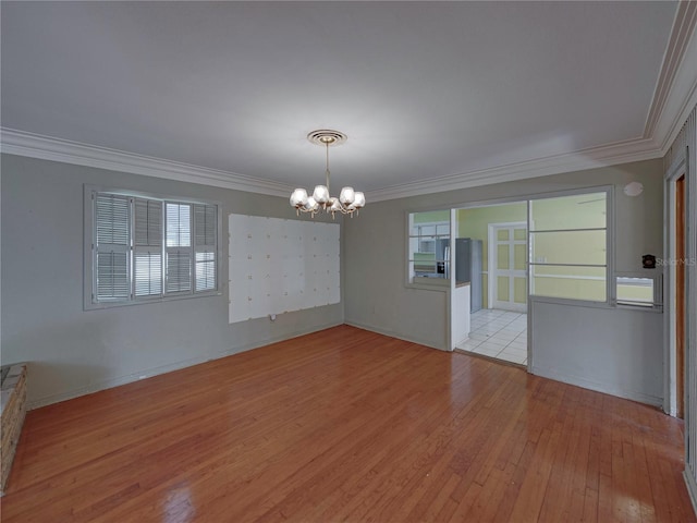 unfurnished room with light hardwood / wood-style floors, ornamental molding, and a chandelier