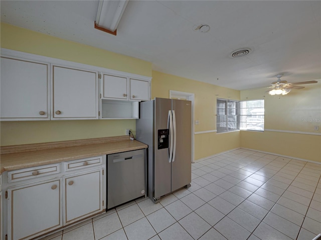 kitchen with light tile patterned flooring, ceiling fan, white cabinets, and stainless steel appliances