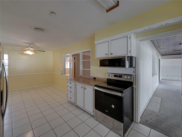 kitchen featuring light carpet, appliances with stainless steel finishes, white cabinetry, and ceiling fan