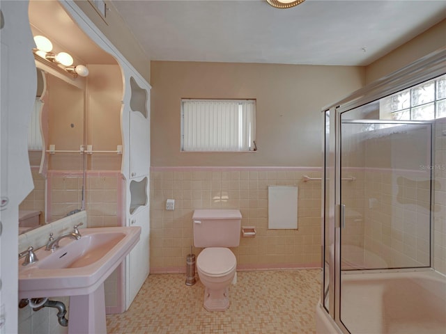 bathroom featuring sink, toilet, walk in shower, and tile walls