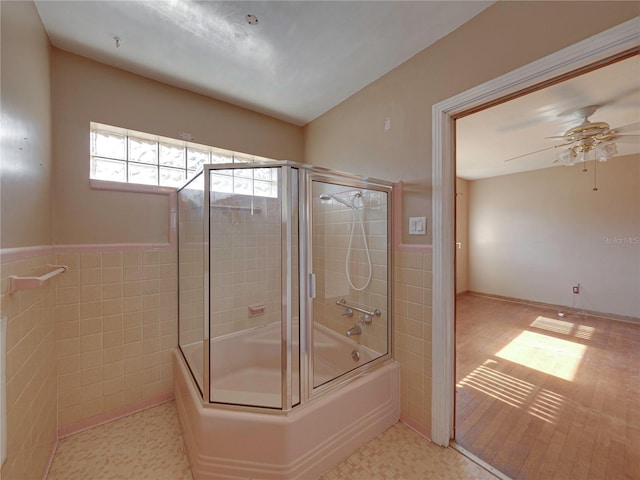 bathroom with ceiling fan, tile walls, and enclosed tub / shower combo