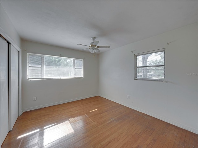 unfurnished bedroom featuring ceiling fan, light wood-type flooring, and a closet