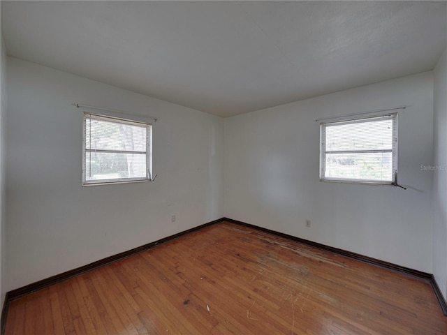 unfurnished room with a wealth of natural light and hardwood / wood-style flooring