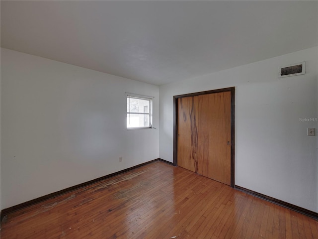 unfurnished bedroom with a closet and hardwood / wood-style floors