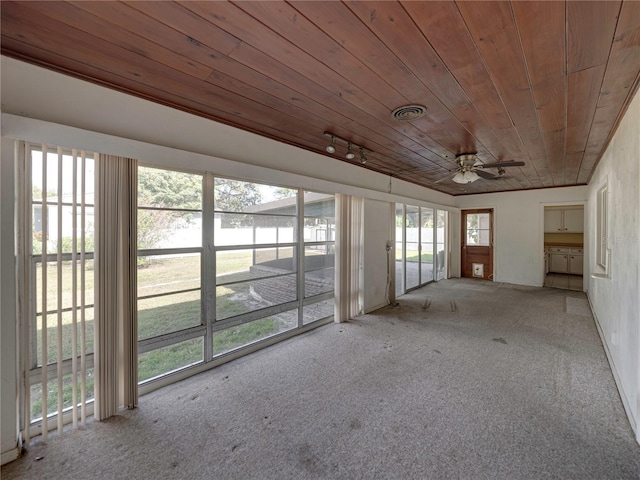 unfurnished sunroom featuring ceiling fan, plenty of natural light, and wooden ceiling