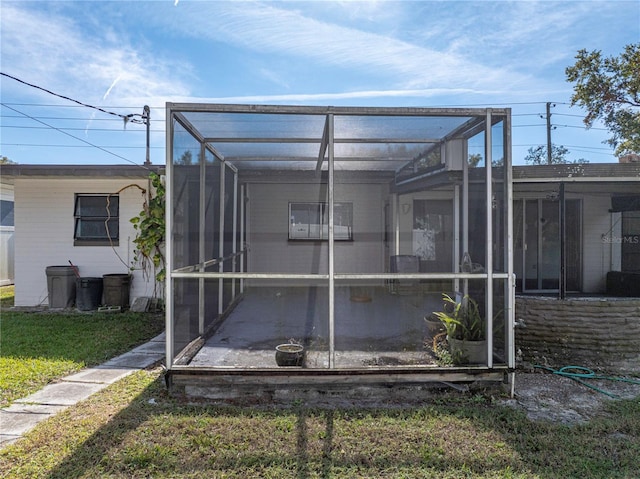 back of house with a lanai and a yard