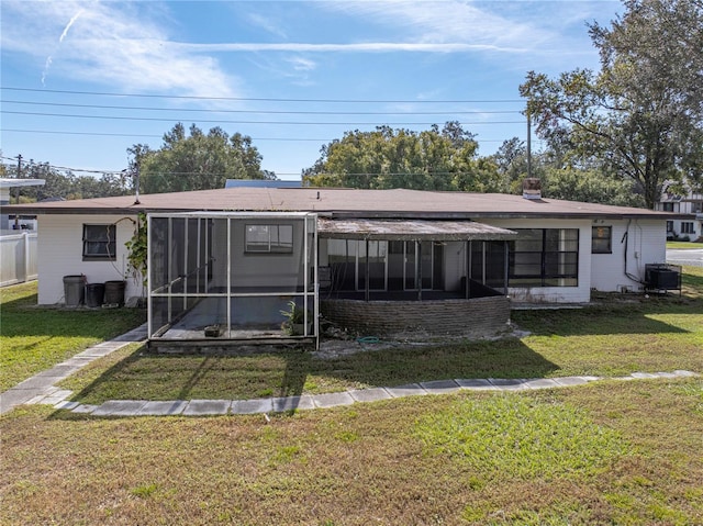 view of front of home with a front yard, cooling unit, and a sunroom