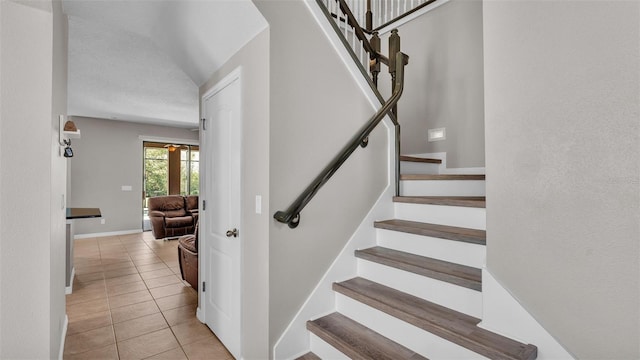 stairs with a textured ceiling and tile patterned floors