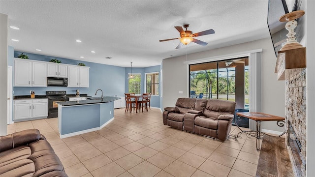 tiled living room featuring a textured ceiling, ceiling fan, and sink