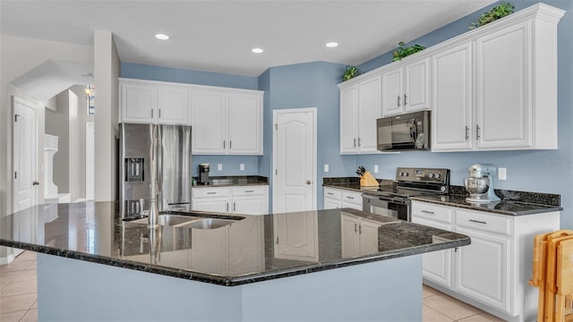 kitchen featuring light tile patterned flooring, white cabinetry, a kitchen island with sink, and appliances with stainless steel finishes