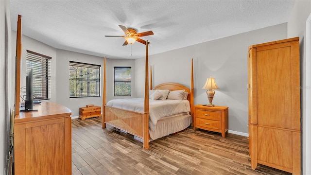 bedroom featuring hardwood / wood-style flooring, ceiling fan, and a textured ceiling