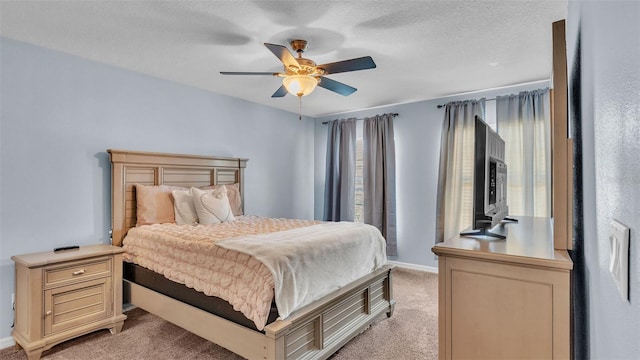 carpeted bedroom featuring ceiling fan and a textured ceiling