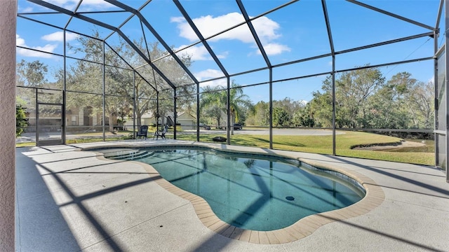 view of pool with glass enclosure, a patio area, and a yard