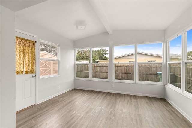 unfurnished sunroom featuring lofted ceiling with beams