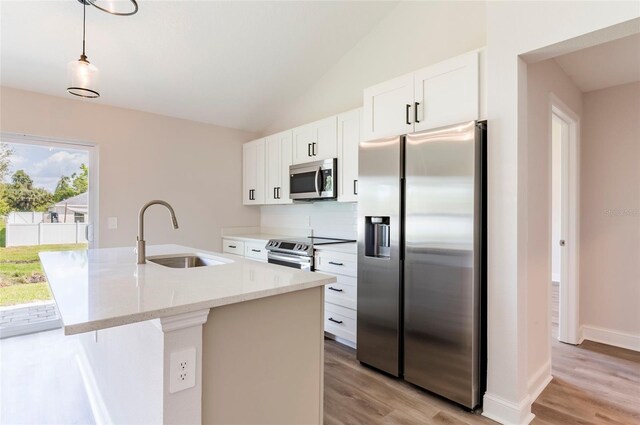 kitchen with stainless steel appliances, sink, decorative light fixtures, light hardwood / wood-style flooring, and white cabinets