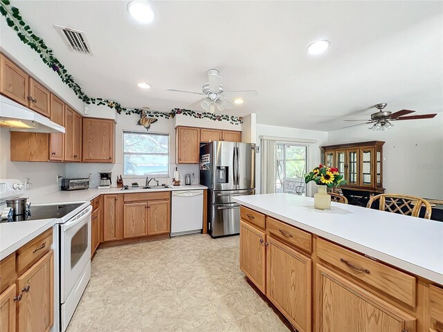 kitchen featuring white appliances, ceiling fan, and sink