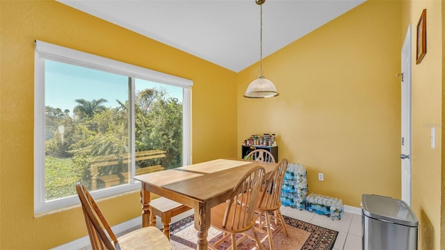 dining area with lofted ceiling, tile patterned floors, and a healthy amount of sunlight