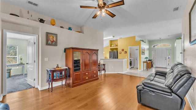 living room with ceiling fan, light wood-type flooring, and washer / clothes dryer