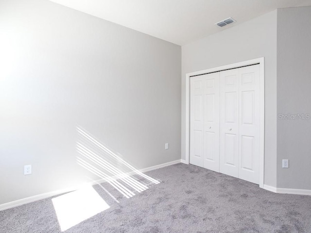 unfurnished bedroom featuring carpet floors and a closet