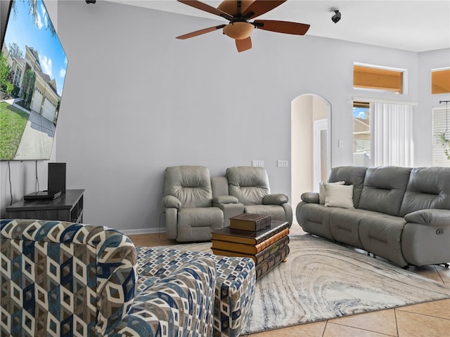 living room featuring ceiling fan, tile patterned flooring, and a towering ceiling