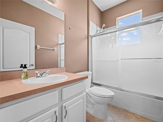 full bathroom featuring toilet, vanity, tile patterned floors, and enclosed tub / shower combo