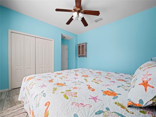 bedroom with hardwood / wood-style floors, ceiling fan, and a closet