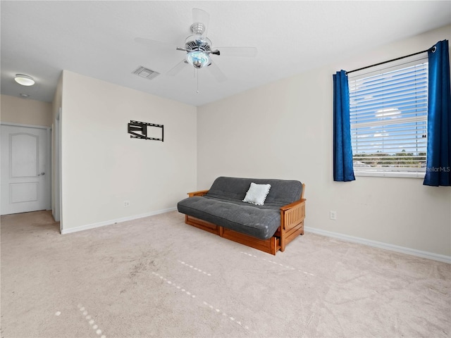 living area with ceiling fan and light colored carpet