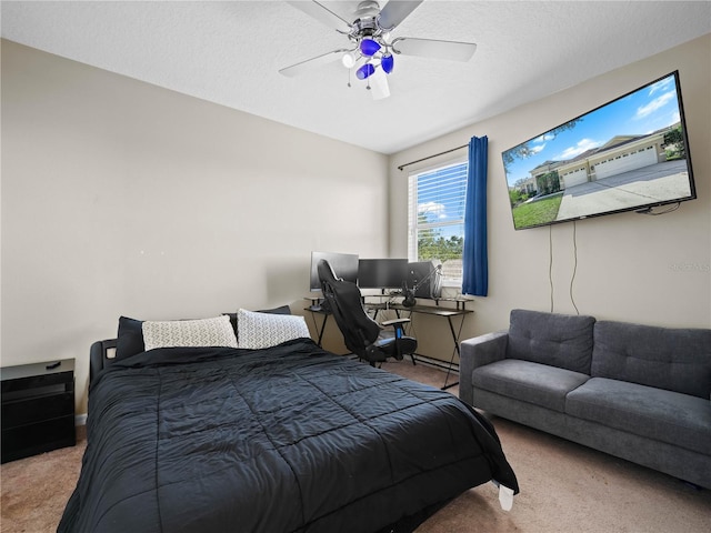 carpeted bedroom with ceiling fan and a textured ceiling