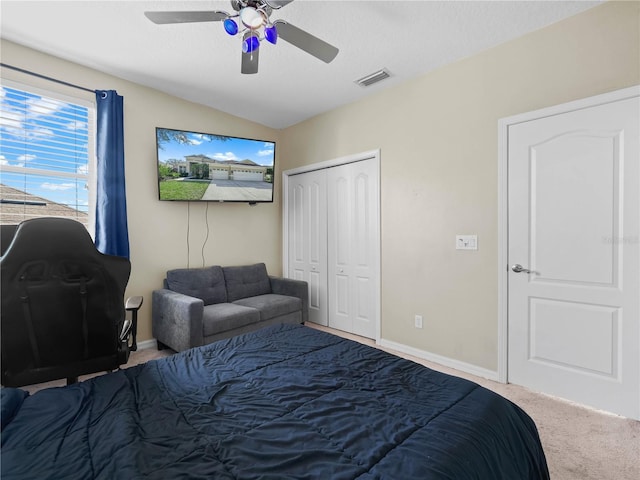 bedroom with lofted ceiling, carpet flooring, ceiling fan, a textured ceiling, and a closet