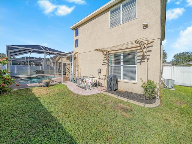 rear view of property featuring a fenced in pool, glass enclosure, a yard, and cooling unit