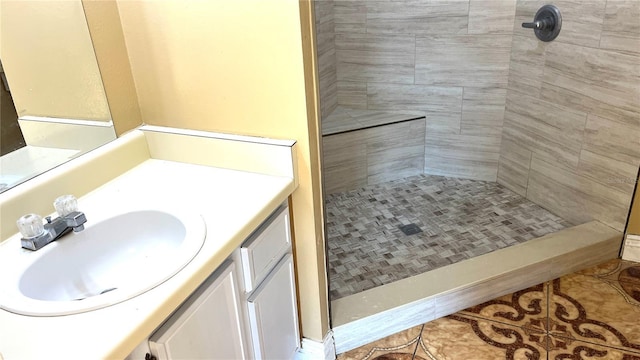 bathroom featuring tiled shower, vanity, and tile patterned floors