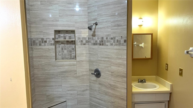 bathroom featuring a tile shower and vanity