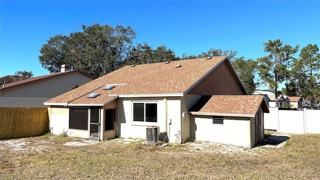 back of house with a sunroom, a yard, cooling unit, and a storage shed