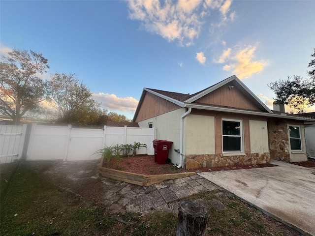 property exterior at dusk featuring a patio area