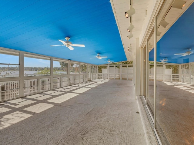 unfurnished sunroom with rail lighting