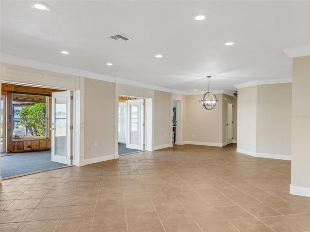 spare room featuring a chandelier, light tile patterned floors, and crown molding