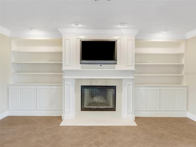 unfurnished living room featuring a fireplace, built in shelves, and crown molding