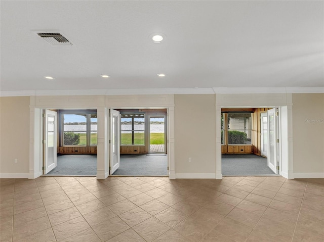 carpeted spare room featuring crown molding