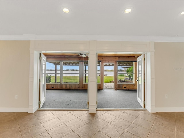 spare room featuring light colored carpet, ornamental molding, and a wealth of natural light