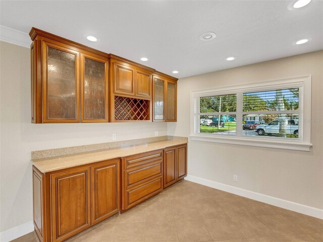 bar with light stone counters and light tile patterned flooring