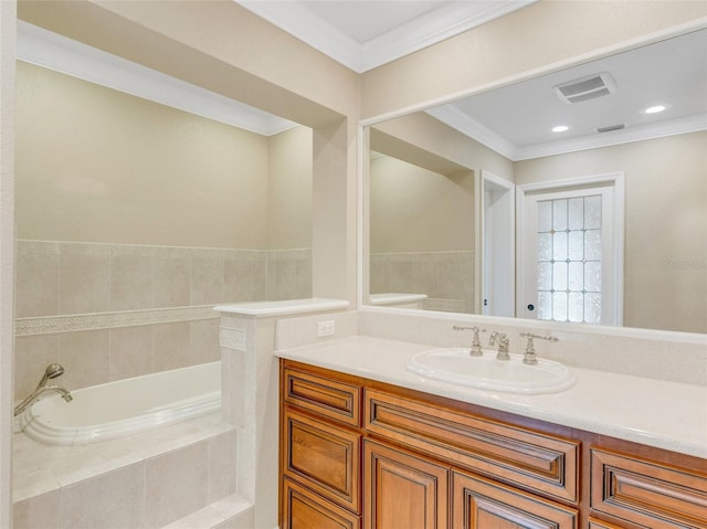 bathroom featuring vanity, ornamental molding, and tiled tub