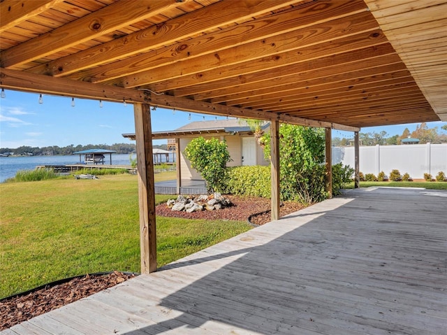 wooden terrace featuring a water view and a yard