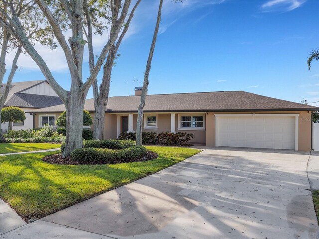 single story home featuring a garage and a front lawn