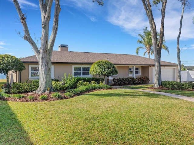 ranch-style home with a garage and a front lawn